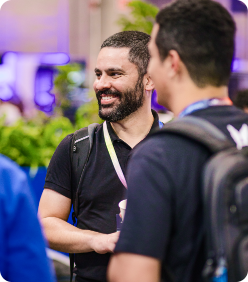 Participantes do Asaas Connect 2024 conversando casualmente e sorrindo.
