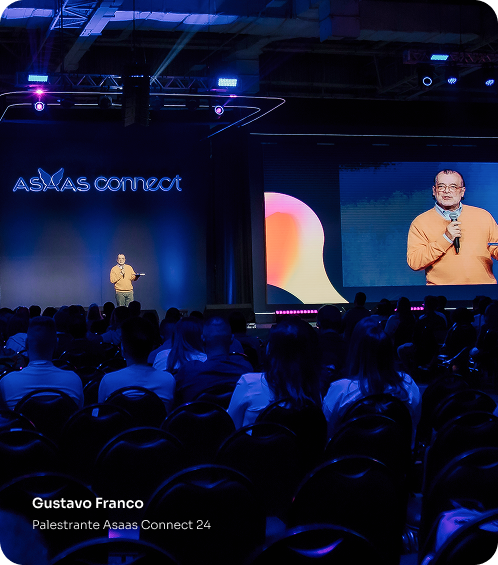 Gustavo Franco palestrando no Palco Connect de 2024. Várias pessoas estão sentadas na plateia.